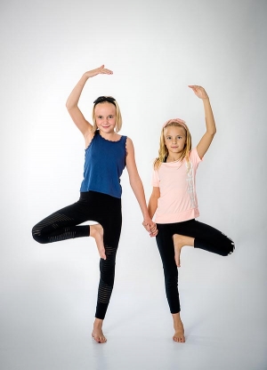 Två barn gör yogaställningar